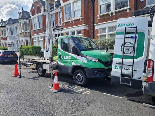a green and white truck with a crane attached to it